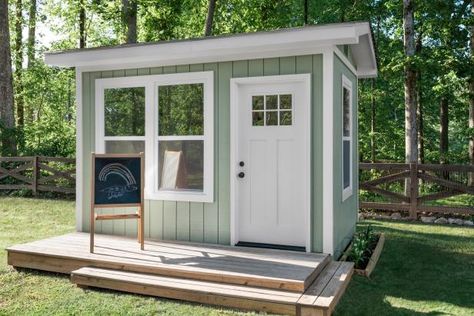 The exterior of the shed was painted a cheerful shade of grey-green which coordinates perfectly with the lush, mature greenery surrounding it.