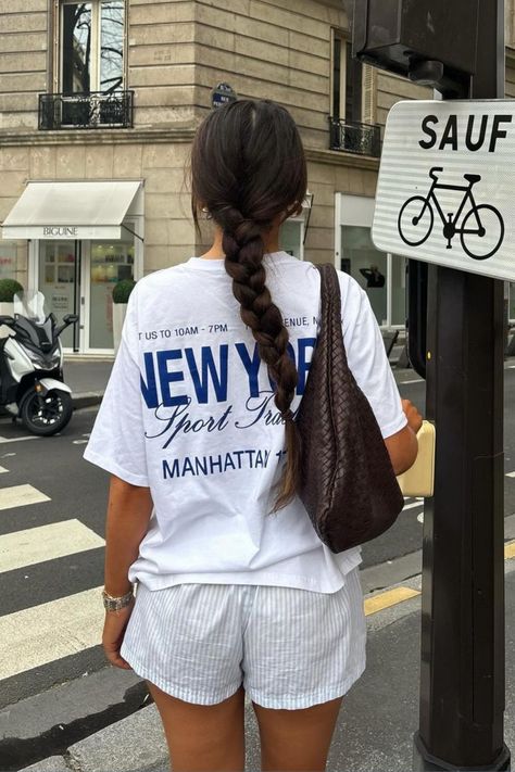 Discover the essence of NYC style with this chic white-on-white ensemble: featuring a stylish graphic tee, paired with pin-striped shorts and accessorized with a trendy brown shoulder bag. Complete the look with braided hair and a sleek silver watch for effortless sophistication. Perfect for the city streets! ✨🗽 #WomensFashion #NYCStyle #WhiteOnWhite #GraphicTee #StreetStyle #FashionInspiration Boxer Short Trend, Chica Chola, Dinner Outfit Casual, Latina Outfits, Look Legging, Stile Hijab, Mode Zara, Skandinavian Fashion, Downtown Outfits