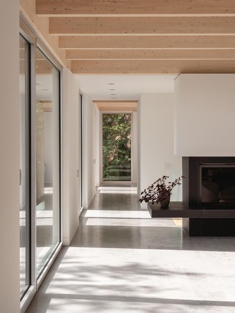 Black Fireplace Surround, Eastern White Cedar, Warm Minimalism, Rocky Landscape, Cabin Aesthetic, Minimal Furniture, Cedar Siding, Concrete Floor, Forest House