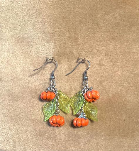 Halloween Pumpkin earrings with green acrylic leaves.  Stainless steel ear hooks and chain. Gift bag included Diy Earrings Halloween, Halloween Handmade Jewelry, Diy Fall Earrings, Diy Halloween Earrings, Christmas Earrings Diy, Diy Christmas Earrings, Halloween Jewelry Diy, Nature Inspired Accessories, Geek Jewelry