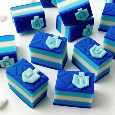 Celebrate Hanukkah in exquisite style with our dreidel rainbow cookies! These stunning treats are layered in shades of blue, topped with a layer of elegant embossed blue, and then topped again with a mini bee dreidel in sparkly aqua blue. A gorgeous addition to your holiday table, and a stunning hostess gift to share Happy Hanukkah greetings with friends and family! What you will get: A gift box with one dozen (12) rainbow cookies in shades of blue and topped with an aqua dreidel. When we will s Hanukkah Village, Hanukkah Treats, Hanukkah Greetings, Hanukkah Cookies, First Night Of Hanukkah, Happy Hannukah, Hanukkah Dreidel, Hanukkah Party, Hanukkah Greeting