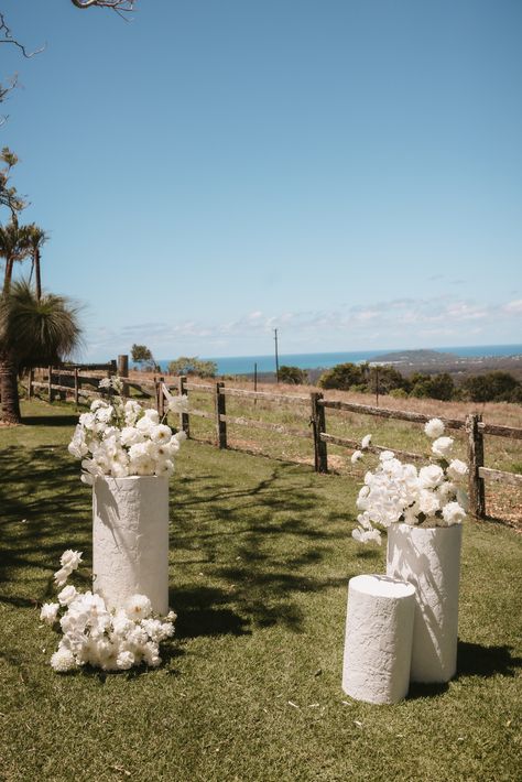 Wedding ceremony on the Eastern lawn at Bryon View Farm. Florals by Wilderness Flowers on The Wedding Shed's White Round Textured Plinths. White Plinths Wedding, Floral Pedestal Wedding Ceremony, Byron Bay Wedding, Ceremony Plinths, Simple Wedding Ceremony Decor, Wedding Plinths, Pedestals Wedding, Simple Ceremony Decor, Plinths Wedding