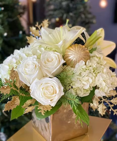 Bring a little class to your holiday this season. Show that special someone how much you love them with this white and gold arrangement. We pulled out the classiest of flowers for this arrangement: hydrangeas, roses, and stargazer lilies. Coming together in a gold square cube, we even included an extra sparkle with gold ornaments. #WelkesFlorist Happy New Year Flowers, Event Planning Decorations, Hydrangea Arrangements, Christmas Floral Arrangements, Stargazer Lily, Classy Christmas, Beautiful Red Roses, Gold Ornaments, Sparkle And Shine