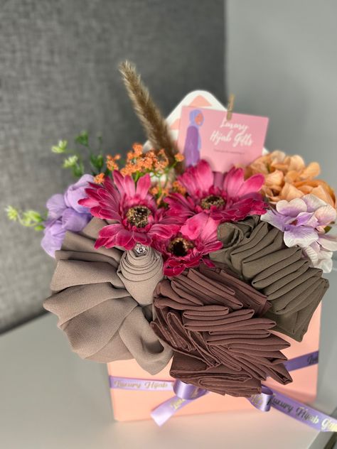 Here is a beautiful hijab hamper made with arrifical flowers and chiffon hijabs. Instgaram: @Luxuryhijabgifts Hijab Hampers Ideas, Hampers Jilbab, Hijab Hamper, Scarf Bouquet, Hampers Hijab, Montage Floral, Hijab Bouquet, Flower Hijab, Wedding Gift Hampers