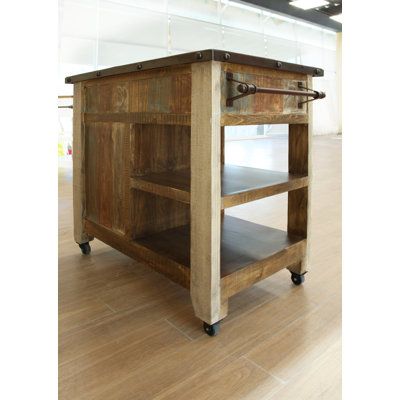 This farmhouse-style kitchen island brings a rustic look to a smaller home while offering extra storage and prep space. Crafted from solid pine wood, it features a brown finish with weathered steel accents and wood scoring for a distressed look. The compact design includes a solid wood countertop, two exterior shelves, one drawer, and a cabinet with two interior shelves, providing ample storage for your kitchen essentials. The island is also equipped with wheels for easy mobility, allowing you t Small Rustic Kitchen Island, Reclaimed Kitchen Island, Farmstead Kitchen, Kitchen Prep Table, Kitchen Island With Stove, Sweet Home Style, Reclaimed Wood Kitchen, Mobile Kitchen, Rustic Kitchen Island