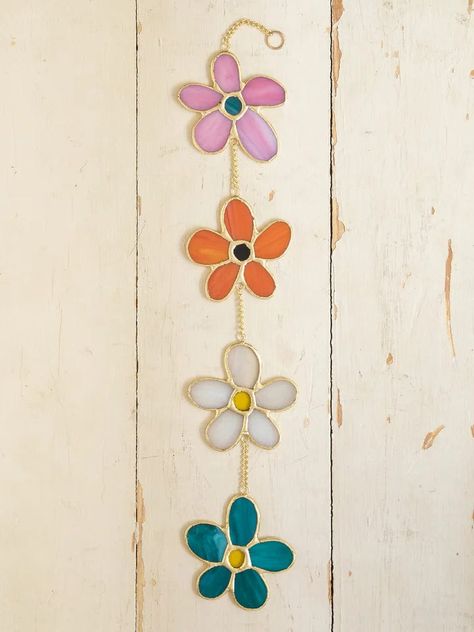 This Stained Glass Mobile is perfect for hanging in a window or on a wall! The opaque colors of the daisy-shaped glass are so beautiful and will add a whimsical feel to any room in your home! It is designed with gold-finished edges and a hook for easy hanging - just hang it on a nail (not included) and you're done! It’s the perfect little addition to your space to make you feel happy! Dimensions: 17.5in L x 3in W Stained Glass Art Window Sun Catcher, Easy Stained Glass Projects, Stained Glass Mobile, Glass Mobile, Tassel Wall, Rainbow Hearts, Stained Glass Window Hanging, Feel Happy, Reversible Quilt