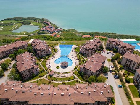 Aerial view of a massive modern hotel complex sprawled beneath, boasting a myriad of swimming pools, sports fields, and royalty free stock images Pool With A View, Modern Hotel, View Image, Aerial View, Swimming Pool, Stock Images Free, Swimming Pools, Lawn, Royalty Free