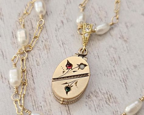 🌺 This amazing dainty gold filled oval shaped locket dates to the Victorian era (c. - Late 1800s- Early 1900s). Featuring a nicely etched floral motif, each flower is represented by a paste stone (white, green and red).  �🌺 It opens from the bottom to reveal two areas in which to place your keepsake photos. The reverse is plain with no monograms in case you would like to add your own.  🌺 It is suspended from a new handcrafted 14k gold filled chain wire wrapped with genuine white freshwater pea Oval Locket Necklace, Oval Locket, White Freshwater Pearl, The Victorian Era, Green And Red, Pearl Chain, Locket Necklace, Green Stone, Early 1900s