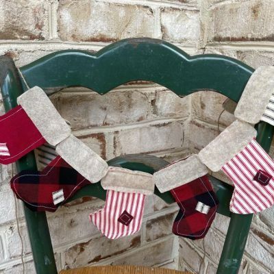 SLEIGH BELL STORIES | Shop Sales Events Antique Farmhouse Mantel Christmas Decor, Stocking Garland, Christmas Stocking Decor, Stocking Decor, Mantel Christmas, Rustic Christmas Stocking, Decorative Garland, Snowflake Garland, Farmhouse Style Christmas