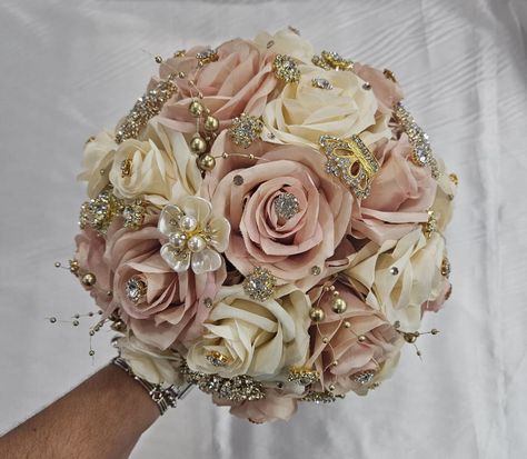 Handmade quinceañera bouquet with Blush Pink and Dark Champagne roses. Finished off with Gold brooches. Décor can be changed upon request. *This is a made to order bouquet* *Please note brooches can change in style based on availability* Rose Gold Quince Ramo, Pink And Gold Theme Quinceanera, Rose Gold Quince Bouquet, Quinceanera Flower Bouquet Pink, Quince Decorations Pink And Gold, Rose Gold Quinceanera Centerpiece Ideas, Pink And Rose Gold Quinceanera Dress, Champagne Quinceanera Theme Decorations, Pink And Gold Quinceanera Decorations