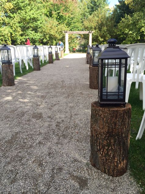 Our mission style lanterns and tree stumps make great aisle decor. Grad Themes, Glitter Ceiling, Isle Decor, Grad 2023, Mums Wedding, Aisle Decorations, Wood Stumps, Romantic Theme Wedding, Aisle Runner Wedding