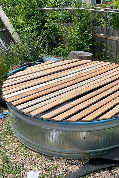 A wood-slatted cover is sitting on top of a metal stock tank pool. Stock Tank Pool Cover Diy, Stock Tank Cover Ideas, Stock Tank Outdoor Bathtub, Stock Tank Pool Covers, Stock Tank Pool Hot Tubs, Stock Tank Pool Liner, Stick Tank Pool Ideas, Diy Stock Tank Pool Ideas, Stock Tank Pool With Deck