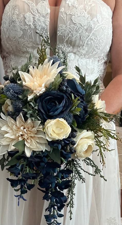 CONGRATULATIONS on your upcoming wedding! This beautiful silk flower bridal bouquet is a romantic inspired blue and ivory bouquet made with a stunning mix of faux/artificial flowers. Gorgeous greenery completes the look and all stems are flawlessly wrapped in ribbon of your color choice. Bouquet measures approx. 14"in diameter by 18" in length (although other diameters are available in drop down menu). Shown here tied with ribbon, but if you are interested in luxurious silk ribbon, this is available for an extra charge. If interested, please message us with the ribbon color you would like.  Matching wedding flowers are also available, so please ask us about a full wedding flower package including bridesmaid bouquets, boutonnieres, corsages and hair wreaths. Your order will be packaged secu Navy Blue Flowers Wedding, Navy Gold Wedding Flowers, Navy Wedding Accents, Navy Blue And Ivory Wedding Decorations, Blue Wedding Ideas Decoration, Navy And Sage Wedding Cake, Navy Blue Flowers Bouquet, Dark Blue Wedding Flowers, Navy Flower Bouquet