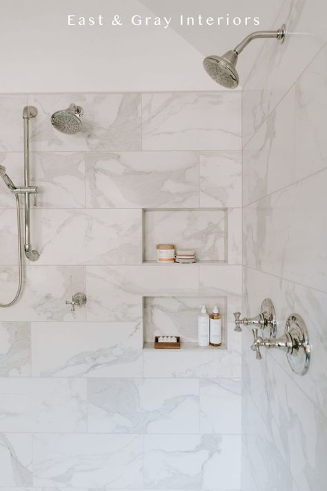 This bathroom design shows off marble like shower tiles with beautiful and functional tile niche! The simplistic design can be both traditional or modern because of its overall timeless look. Want more shower tile ideas? Check out the rest of this bathroom renovation at East & Gray Interiors. Carrera Tile Shower Wall, 6x12 Tile Bathroom Shower Walls, White Bathroom Gray Floor, Show Tile Ideas, Shower Niche Large Tile, White And Gray Tile Shower Ideas, Vertical Marble Tile Shower Walls, Marble Tile Bathtub, 6x12 Shower Wall Tile