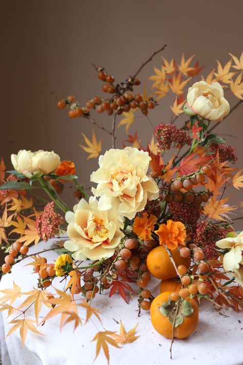 Autumnal Yellow & Orange Floral Arrangement with persimmons Persimmon Floral Arrangement, Fall Flower Arrangements Wedding Autumn Centerpiece Ideas, Persimmon Arrangement, Autumn Wedding Flowers Centerpieces, Persimmon Aesthetic, Fall Floral Arrangements Centerpiece, Orange Arrangements, Fall Arrangements Floral Design, Orange Floral Arrangements