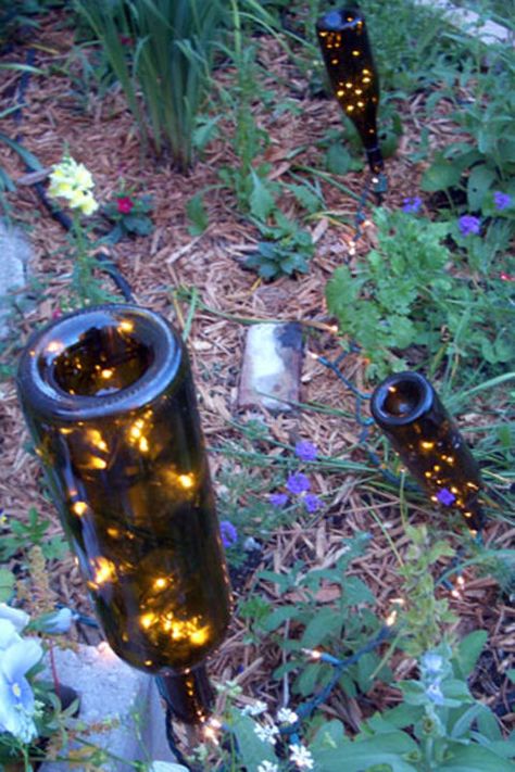 Garden Lanterns:  A few bottles, Christmas lights, and stakes are all you need to create some magical ambiance in your backyard. Wine Bottle Garden, Old Wine Bottles, Bottle Trees, White Christmas Lights, Empty Wine Bottles, Bottle Tree, Bottle Garden, Wine Bottle Diy Crafts, Garden Lanterns