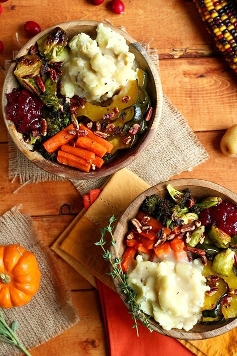 This recipe for a Roasted Vegan Thanksgiving Bowl is perfect for getting you into the holiday spirit, thanks to its blend of savory comfort food ingredients like sweet roasted squash and carrots, roasted garlic broccoli, roasted brussels sprouts, mashed creamer potatoes, and easy gravy sauce. Or, try out this recipe after Thanksgiving for a creative way to use leftovers. Thanksgiving Bowl, Vegan Thanksgiving Dinner, Pudding Chia, Vegan Holiday Recipes, Vegetarian Thanksgiving, Decorações Com Comidas, Vegan Thanksgiving Recipes, Vegan Thanksgiving, Vegan Cooking