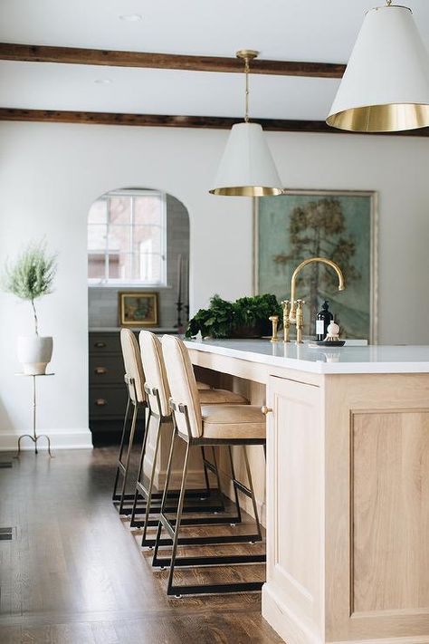 Light brown leather counter stools sit at a light brown brushed oak center island fitted with an antique brass deck mount faucet and an apron sink illuminated by two white and gold Goodman Hanging Lamps. Banquette Living Room, Jean Stoffer Design, Jean Stoffer, Kitchen Post, Brass Interior, Leather Stool, Home Luxury, Painted Brick, Large Kitchen