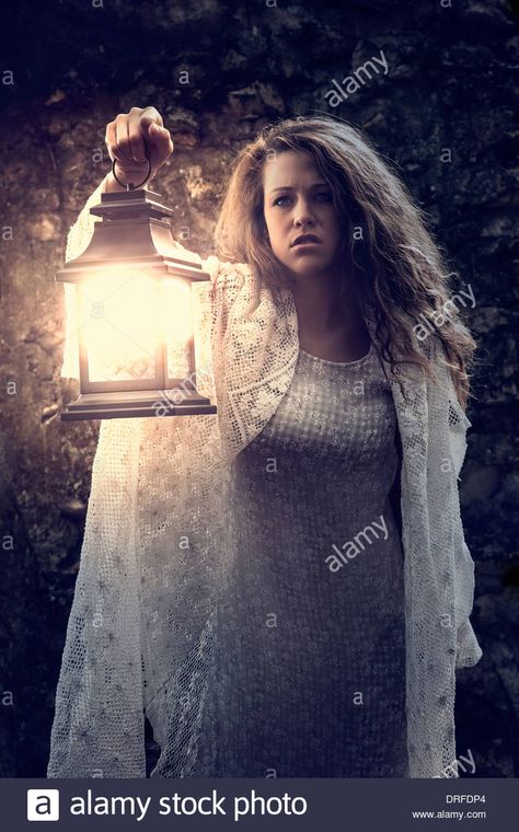 Woman holding lantern in the dark Stock Photo: 66108284 - Alamy Carrying Lantern Reference, Holding A Lamp Reference, Woman Holding Something Pose, Holding Lantern Pose Reference Drawing, Woman Casting Spell Pose, Holding Lantern Pose Reference, Hand Holding Lantern Reference, Person Holding Candle Reference, Person Holding Flashlight Reference