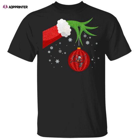 Get into the holiday spirit and show off your love for the Tampa Bay Buccaneers with our festive Grinch Christmas Ornament Tampa Bay Buccaneers Shirt! This unique and eye-catching shirt combines the beloved holiday character, the Grinch, with your favorite NFL team, creating a one-of-a-kind design that is sure to turn heads.

Our shirt is crafted from high-quality, soft fabric that ensures a comfortable fit all day long. The vibrant colors and intricate details of the design make it a standou...