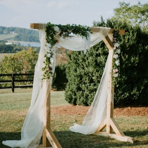 A simple wooden structure made elegant with tule and floral arrangements. This wedding arch made for a beautiful accessory to our bride and groom but did not take away from the natural beauty of the Blue Ridge Mountains.

Photographer: Mary Catherine Photography
Venue: @wolftrapfarm in Charlottesville, Virginia
Planner: Details and Lace Wooden Wedding Arch With Drape, Simple Wood Arch Wedding, Wood Ceremony Arch, Wooden Arch Wedding Decor, Simple Rustic Wedding Arch, Natural Wood Wedding Arch, Wooden Wedding Arbor, Diy Simple Wedding Arch, Wooden Wedding Arch Ideas