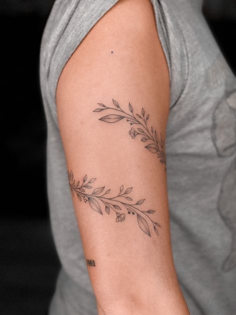 Leaf Wrap Around Tattoo Bicep, Floral Wrap Around Bicep Tattoo Women, Bicep Vine Tattoo Women, Greenery Wrap Around Tattoo, Dainty Floral Vine Tattoo, Ivy Arm Tattoos For Women, Flower Wrap Around Tattoo Upper Arm, Fine Line Floral Tattoos, Vine Tattoos Upper Arm