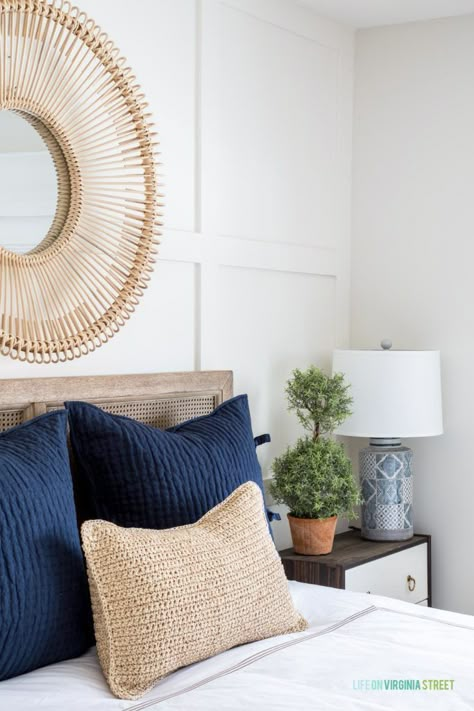 Gorgeous shot of the navy blue throw pillows, textured natural lumbar throw pillow, round rattan mirror, mini topiary tree on the nightstand, and a gorgeous organic feel. Loving this spring guest bedroom! #bedroomdecor #springdecor #sponsored Round Rattan Mirror, Bedroom Spring, Navy Blue Throw Pillows, Topiary Tree, Rattan Mirror, Master Decor, Coastal Bedroom, Blue Throw Pillows, Guest Bedrooms