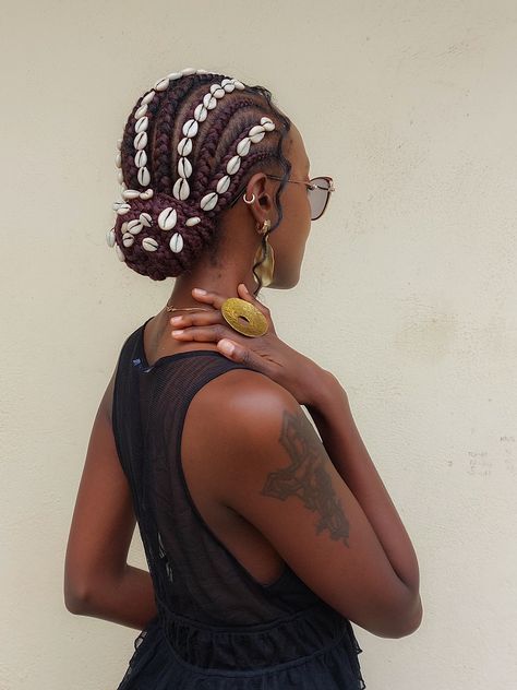 Girl with african cornrows hairstyle with cowrie shells sewed on them Cornrows With Cowrie Shells, Short Beaded Cornrows, Cowrie Shell Hairstyles, Braids With Cowrie Shells, Shells In Locs, Cornrows Outfit, Shell Braids, Cowrie Shell Tattoo, Shells In Hair