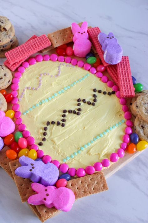 Decorative Easter-themed cookie cake with pastel icing, surrounded by colorful candies and bunny-shaped marshmallows. Easter Dessert Board, Easter Bunny Desserts, Seasonal Cookies, Dessert Charcuterie Board Ideas, Easter Themed Treats, Bunny Desserts, Mini Carrot Cake, Easter Egg Decorating Ideas, Dessert Charcuterie Board