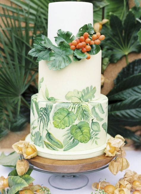 Inspired by a tropical print, this cake design by Krishanthi Armitt features hand-painted palm and monstera leaves on the bottom tiers. A collar of monsteras surrounds the base of the top tier and is accented with a cluster of bright berries, all intricately sculpted from sugar. Fruit Wedding Cake, Tropical Wedding Cake, Tropical Wedding Theme, Green Wedding Cake, Summer Wedding Cakes, Exotic Wedding, Traditional Wedding Cake, Wedding Cake Flavors, Cake Trends