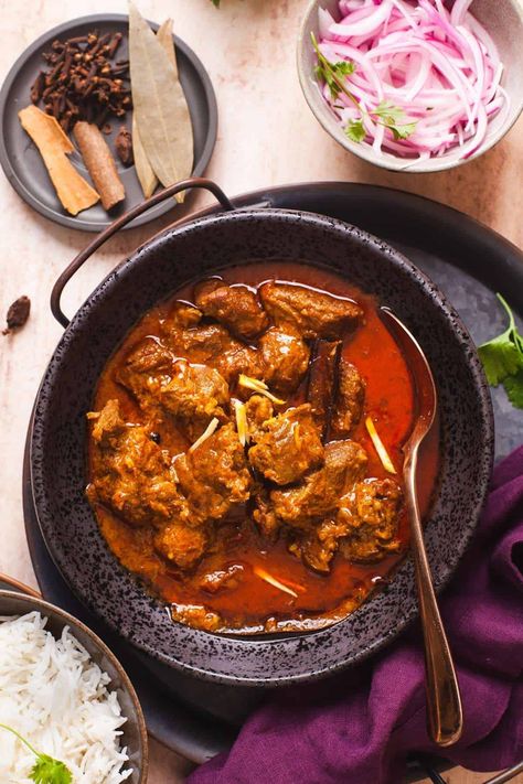 Indian lamb curry served in a black dish with rice and sliced onions on the side. Spicy Lamb Curry, Lamb Chop Recipes Indian, Indian Lamb Curry Recipes, Curried Lamb Recipes, Lamb Chunks Recipes, Lamb Curry Recipes Indian, Indian Lamb Recipes, Beef Curry Recipe Indian, Lamb Recipes Indian