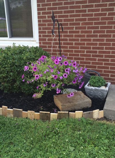 Pallet wood used as edging around flower beds Flower Bed Boarder Landscape Edging, Pallet Wood Flower Bed Border, Wooden Lawn Edging, Flower Bed Wood Border Ideas, Triangle Flower Bed Ideas, Wood Landscape Edging Ideas, Pallet Garden Edging, Pallet Edging, Flower Border Ideas