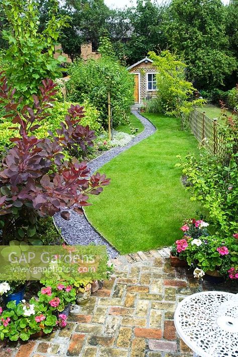 Elevated view of long, narrow town garden with lawn and sinuous path leading to garden studio. Brick paving, slate chippings, Cotinus, pots of Pelargoniums. Narrow Garden, Back Garden Design, Garden Design Layout, Garden Design Plans, Outdoor Gardens Design, Beautiful Flowers Garden, Backyard Garden Design, Garden Studio, City Garden