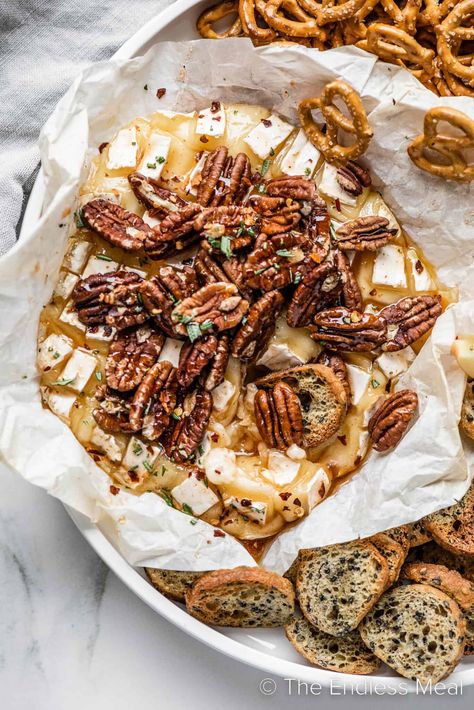 This hot honey baked brie is gooey and sweet with a little heat. It's a wheel of brie cheese baked with homemade hot honey, and topped with pecans and fresh rosemary. It's an easy party appetizer that everyone loves, and it's ready in just 20 minutes! #theendlessmeal #bakedbrie #cheeseboard #brie #partyrecipes #holidayrecipes Honey Baked Brie, Homemade Hot Honey, Baked Brie Honey, Honey Appetizers, Honey Brie, Brie Cheese Recipes, Hot Honey Recipe, Pecan Baked Brie, Baked Brie Appetizer