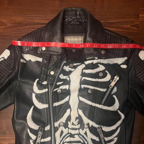 Burberry Leather Motorcycle Jacket with hand painted Skeleton design all over. 
One of a kind custom hand painted leather jacket with skeleton detail front / back / sleeves.
100% genuine leather. 
Size small, will fit men's 38 jacket.

The skeleton design is hand painted after purchase of the Burberry jacket, (Not painted by Burberry). This is a unique one of a kind original jacket.

AS IS: Lining needs repair. Bottom slider of 2 way separating zipper has been replaced. 

#goth #punk #punkrock #skeleton #oneofakind Hand Painted Leather Jacket, Painted Leather Jacket, Burberry Jacket, Custom Hand Painted, Leather Motorcycle Jacket, Burberry Men, Punk Rock, Mens Fitness, Motorcycle Jacket