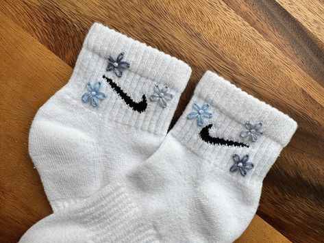 Elevate your sock game this season with our floral hand embroidered socks. These socks feature delicate blue daisies, making them the perfect accessory for spring and summer. Whether treating yourself or someone special, these socks make a great gift. Choose from ankle (shown in listing photos) or crew length for a stylish addition to any outfit. See other listings for different colourways. Size Guide: US S = UK 3-5 US M = UK 5-8 US L = UK 8-11 Safe to machine wash at 30-40o but do not tumble dr Embroidered Nike Socks, Cute Nike Socks, Socks Nike, Stitch Sweatshirt, Blue Daisies, Vintage Nike Sweatshirt, Embroidered Socks, Trendy Socks, Personalized Sweater