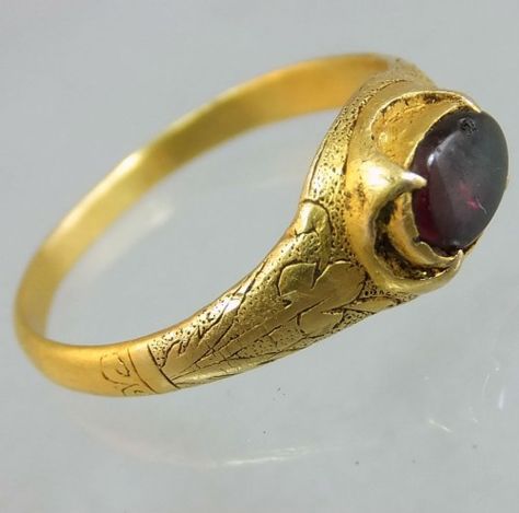 English ca 1480-1500 gold ring in cusped setting holding a garnet. The sides or the shoulders of the ring are engraved with stylised leaves, and stippled or shaded background. Rare to have t... Medieval Ring, Medieval Style Gold Jewelry With Antique Finish, Handmade Medieval Round Jewelry, Bronze Engraved Medieval Jewelry, Handmade Medieval Gold Rings, Ornate Garnet Round Rings, Ancient Gold Ring, Historical Rings, Medieval Wedding Ring