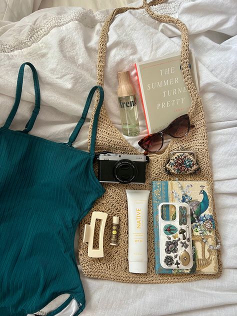 Summer aesthetic beach bag with swimsuit, sunglasses, and other aesthetic beach day items. What To Pack For Beach Day, Bag For Beach Summer, Whats In My Beach Bag Summer, Whats In My Bag Beach, Beach Bag Necessities, Summer Car Bag, Summer Beach Essentials, Whats In My Bag Summer, What's In My Beach Bag