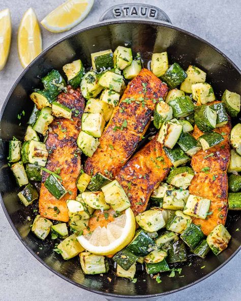 top view salmon filets cook on a black skillet with chunks of zucchini Squash And Salmon Recipes, Salmon With Zucchini And Squash, Salmon Low Cholesterol Recipes, Salmon And Squash, Salmon Zucchini Recipes, Salmon Chunks Recipe, Salmon And Zucchini Recipes, Salmon Squash, Salmon With Zucchini