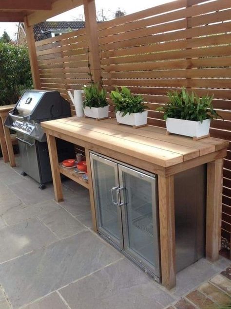 a small outdoor kitchen with a large wooden kitchen island and a drink cooler built in under the top, a grill next to it is cool Design Per Patio, Small Outdoor Kitchens, Small Outdoor Kitchen, Outdoor Kitchen Decor, Outdoor Kitchen Plans, Outdoor Bbq Kitchen, Outdoor Kitchen Ideas, Patio Kitchen, Backyard Kitchen