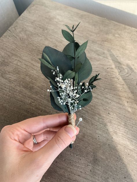 This boutonnière is made with preserved eucalyptus and dried gypsophila flowers. Perfect for groom, groomsmen, father of the bride or ring bearers. A classic design, a great fit for any wedding or event! The buttonhole is everlasting since the florals are preserved. Pins are included. Feel free to get in touch if you have any questions! We are happy to make custom orders if you have any special requests. Thank you for shopping at Blooma! Groom Boutonniere Eucalyptus, Flowers For Groom Boutonnieres, Buttonhole Flowers Groomsmen, Sage Wedding Boutonniere, Eucalyptus Wedding Boutonniere, Greenery Boutineer Groomsmen, White And Eucalyptus Boutonniere, Men’s Flowers For Wedding, Wedding Groom Flower Pin