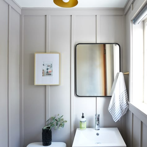 This powder room remodel takes a dated space (with cherubs on the ceiling!) and turns it into a modern classic with board and batten walls and brass accents. Grey Board And Batten Bathroom, Floor To Ceiling Board And Batten Bathroom, Modern Board And Batten Bathroom, Grey Board And Batten Wall, Powder Room Board And Batten, Bathroom Wall Treatments, Board And Batten Powder Room, Grey Board And Batten, Panel Hallway