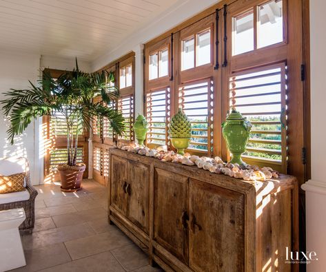 Stepping inside the guest suite from the balcony, custom jalousies--a window design Schaub borrowed from Jamaica--in unfinished cypress allow the homeowners to control airflow and will eventually add a nice silvery patina to the home's exterior color palette. Tropical Bungalow, Tropical Windows, Tropical Beach Houses, Tropical Interior Design, Exterior Color Palette, Tropical Retreat, Southern Coastal, Tropical Interior, Huge Library