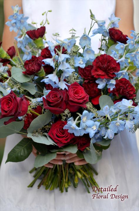 This red and blue bridal bouquet by Detailed Floral Design features delphinium, black baccara roses, carnations and eucalyptus. Detailed Floral Design creates uniquely personal wedding flowers for brides in North San Diego County and Temecula Valley. #DetailedFloralDesign Blue Red Bouquet, Red And Blue Bouquet Wedding, Wedding Red And Blue, Red And Blue Bridal Bouquet, Blue And Red Wedding Flowers, Red Carnations Bouquet, Red Blue Wedding Theme, Light Blue And Red Wedding, Red Blue Bouquet