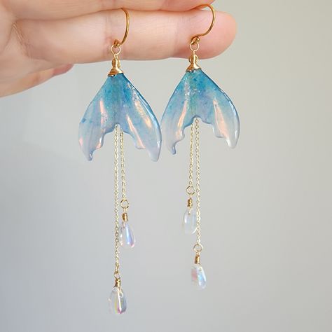 Discover the beauty of iridescent mermaid tail earrings in this stunning collection. These unique and eye-catching accessories are sure to make a splash wherever you go. Perfect for adding a touch of whimsy and magic to any outfit. Whether you're attending a wedding, a formal event, or simply want to add a touch of fierceness to your everyday look, these earrings are a versatile and stylish choice. 🍊Material: The earrings are made with shimmering resin mermaid tails, Czech glass water drops and the 14K gold plated (nickel-free) hooks. Handmade in Maryland, USA! 🌺Size: approx.(W x L) 2.54cm x 9.5cm 🎀Handmade jewelry: Each item is made to order, which gives our pieces a unique meaning that is specific and special to you.Therefore, there are no two items exactly alike. Contains small parts Mermaid Tail Craft, Mermaid Accesories, Hoverboard Girl, Graduation Accessories, Water Accessories, Mermaid Tail Earrings, Magic Earrings, Magical Earrings, Coworker Appreciation