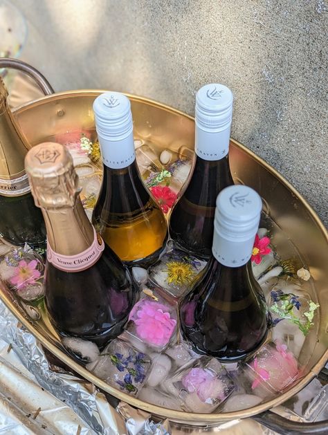 Champagne and white wine bucket with floral ice cubes Wine Display For Party, Ice Champagne Bucket, Ice Bucket Wedding, Champagne Bucket Flowers, Ice Bucket For Party, Wine Bucket Ideas, Wine Table Display, Wedding Ice Bucket, Folklore Party