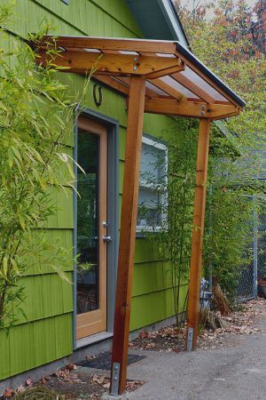 Garage Door on North Side of house. I like this full glass door and the wood structure. What do you call that? Front Door Canopy Wood, Simple Door Awning, Modern Awnings Front Door, House Ideas Exterior Modern, Front Door Covered Entry, Partial Pergola, Small Pergola Patio, Door Awning Ideas, Modern Front Entry