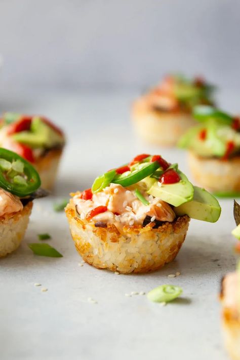 These spicy salmon sushi cups feature crispy rice cups filled with a sriracha salmon filling and topped with lots of fresh avocado and jalapeno. Salmon Sushi Cups, Sushi Cups, Spicy Tuna Sushi, Rice Cups, Spicy Salmon Sushi, Sriracha Salmon, Salmon Appetizer, Crispy Salmon, Flaked Salmon