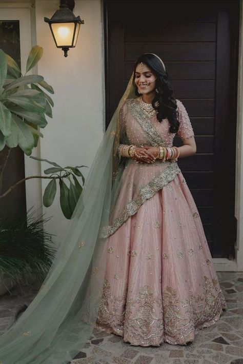 When it comes to wedding lehengas, red has always been a favourite with brides. But off late, brides are giving the traditional red lehenga a miss and opting for a different and unique hue when it comes to picking up their bridal lehenga – powder pink! A pale shade of pink that is in the pastel family has been a bridal favourite off late for your wedding day. It’s perfect for a day wedding as well as an evening soiree, light enough to not overpower you as well as unique enough to style. Pastel Pink Bridal Lehenga, Pastel Pink Lehenga, Green Indian Wedding, Pink Indian Wedding, Green Bridal Lehenga, Bridal Lehenga Images, Sabyasachi Lehenga Bridal, Pink Bridal Lehenga, Pastel Pink Weddings