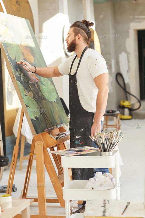 Bearded Male Artist Painting on Easel in Workshop by seventyfourimages. Vertical full length portrait of contemporary bearded artist painting picture on easel while working in art studio li... #Sponsored #seventyfourimages, #Workshop, #Vertical, #length Painter Pictures, Male Artists, Painter Photography Artists, Artist At Work Photography, Painter Painting, Artist Photo, Artist Working, Paint Workshop, Male Artist Aesthetic